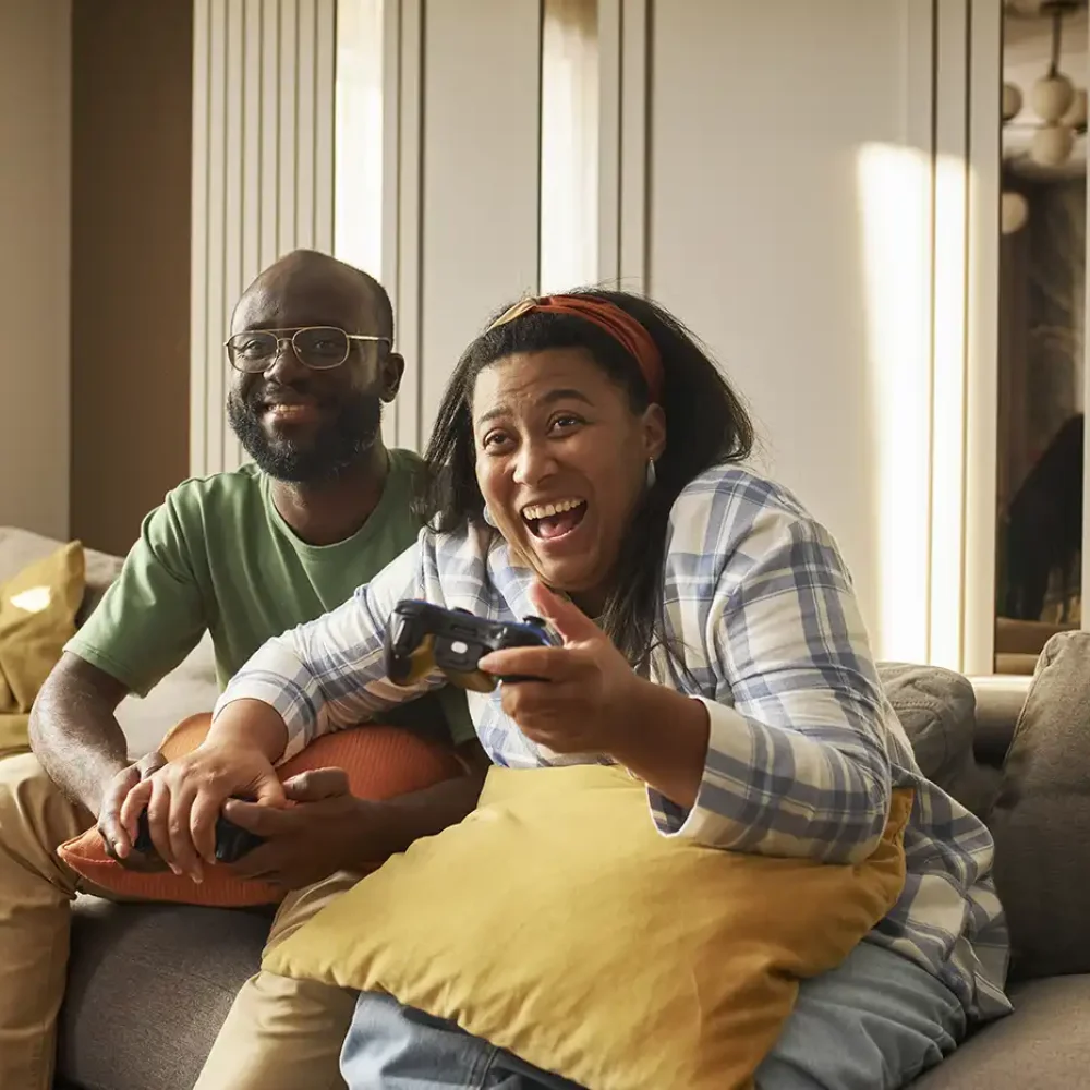 Couple playing video games at home